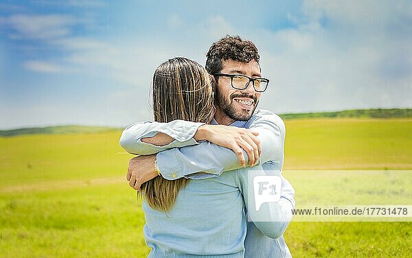 Ein Mann umarmt seine Frau in einem schönen Feld  Nahaufnahme eines glücklichen Paares  das sich im Feld umarmt  ein junges verliebtes Paar  das sich im grünen Feld umarmt