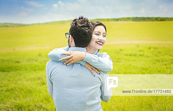 Nahaufnahme eines glücklichen Paares  das sich auf einem Feld umarmt  ein junges verliebtes Paar  das sich auf einer grünen Wiese umarmt  ein Mann  der seine Frau auf einem schönen Feld umarmt