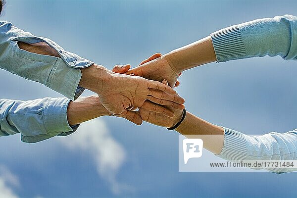 Konzept  daß eine Hand über der anderen ein Team bildet  Konzept der Einheit mit den Händen  Handflächen zusammen  alle für einen und einer für alle  gekreuzte Hände in einem Konzept der Einheit