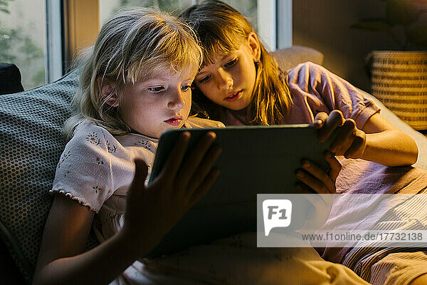 Sisters watching tablet PC at home