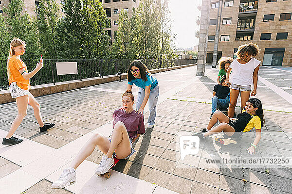 Girls skateboarding enjoying with friends at parking lot