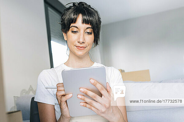 Woman using tablet PC at home