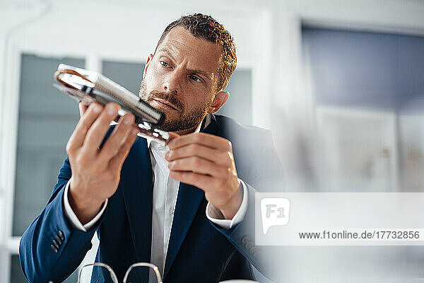 Concentrated businessman examining heating module in office