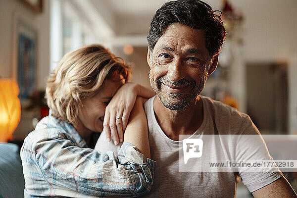 Smiling mature man sitting with woman at home
