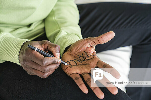 Man writing peace on palm of hand