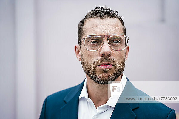 Serious businessman with hair stubble wearing eyeglasses
