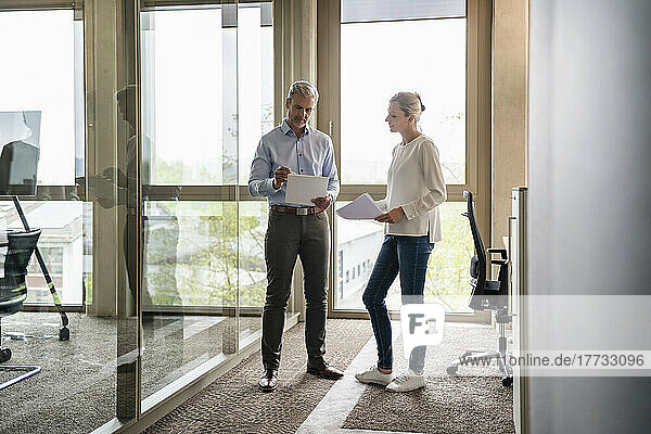 Businessman and businesswoman talking in office