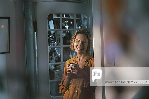 Happy mature woman with coffee cup at home
