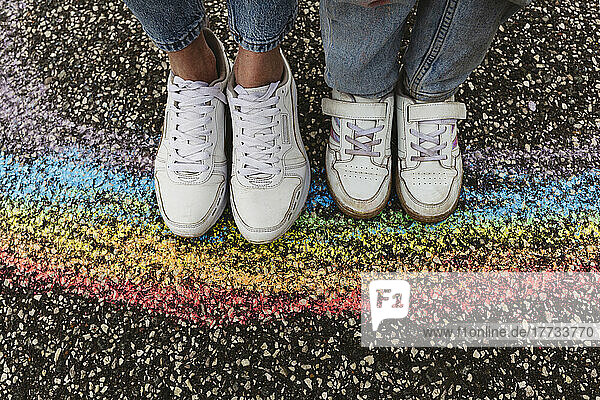 Mother and daughter standing on rainbow drawing