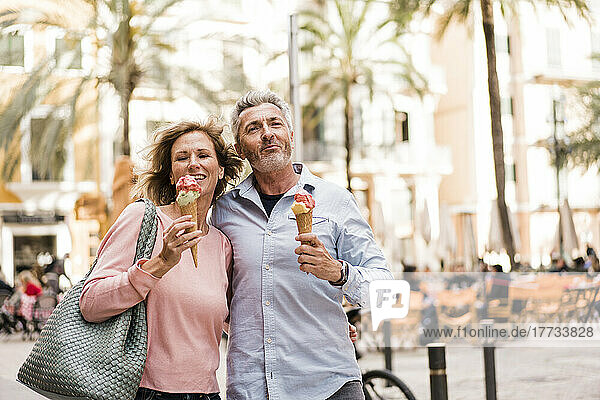 Mature couple enjoying ice cream in sidewalk cafe