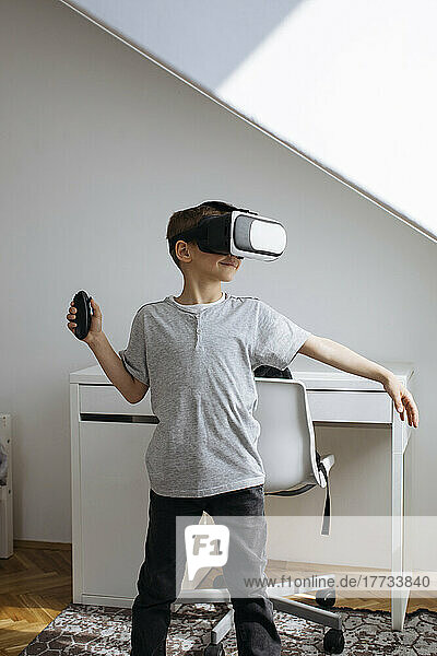 Junge spielt zu Hause Videospiel auf einem Virtual-Reality-Simulator