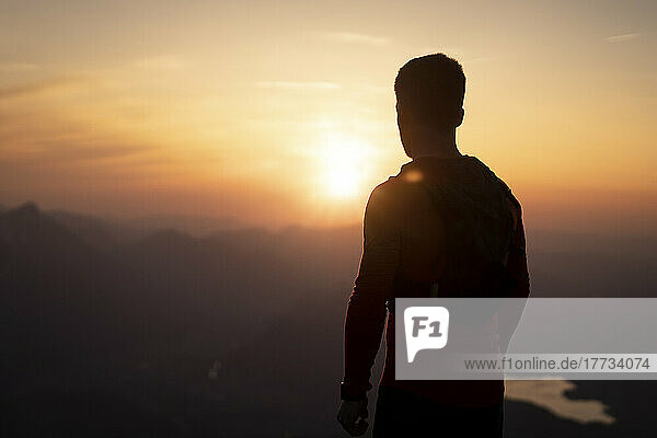 Silhouette eines Mannes  der den Sonnenuntergang vom Sauling-Berg aus betrachtet