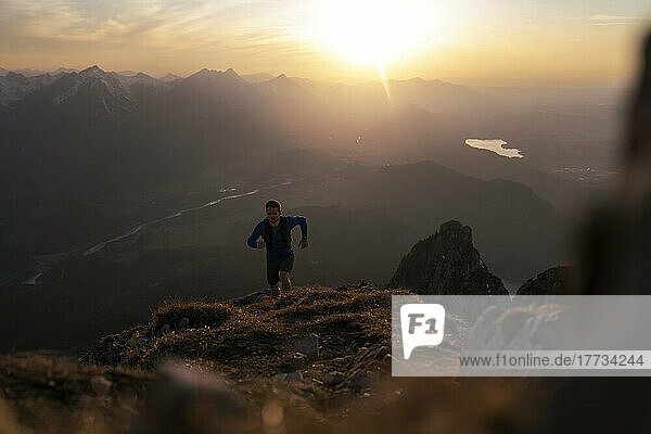 Mann wandert bei Sonnenuntergang auf dem Sauling-Berg