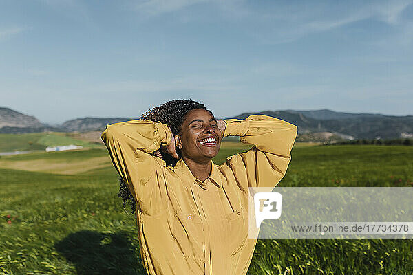 Happy woman standing with eyes closed enjoying sunny day