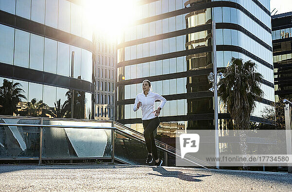 Frau joggt vor modernem Gebäude