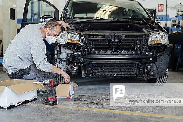 Auto expert repairing car in workshop