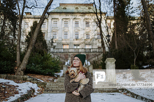 Woman with Yorkshire Terrier standing in front of building