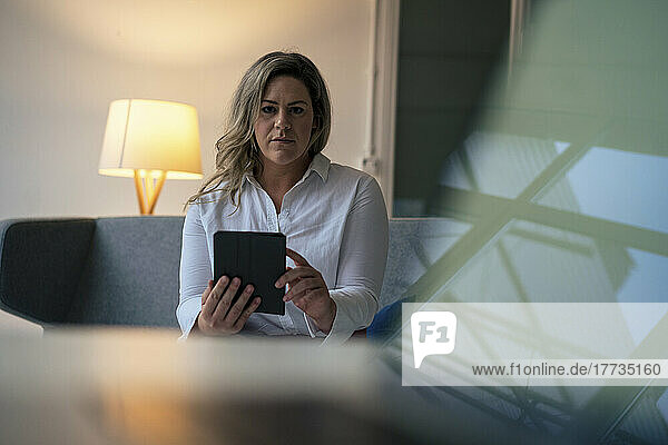 Confident businesswoman with tablet PC in office