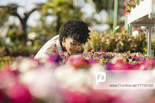 Florist smelling fresh flowers at plant nursery
