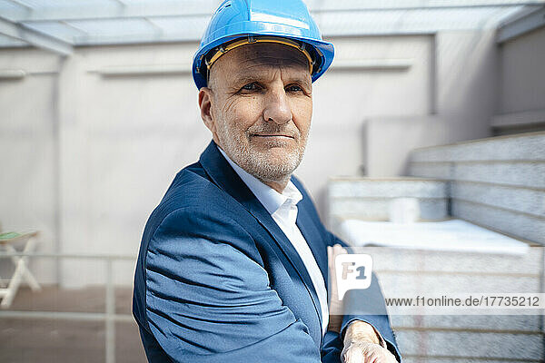 Businessman with arms crossed at construction site