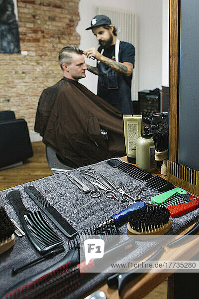 Various scissors and combs on napkin at hair salon