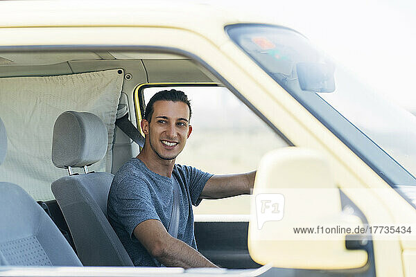 Smiling young man driving van