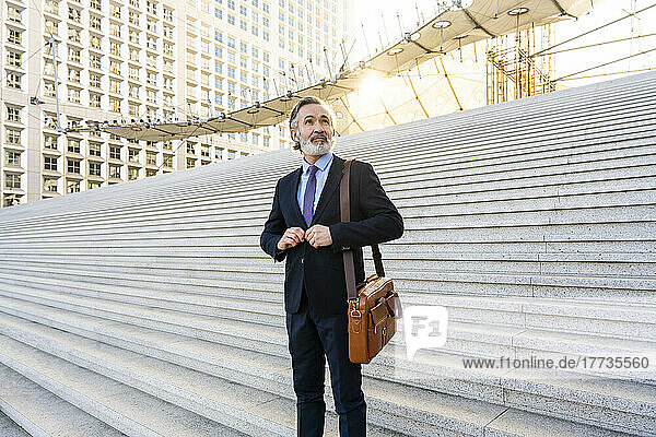 Mature businessman with beard standing on staircase