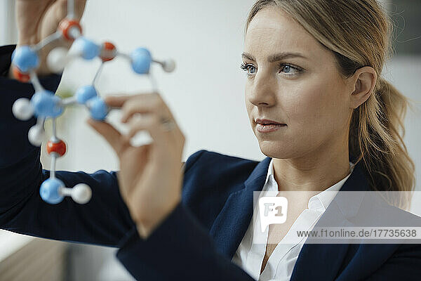 Businesswoman analyzing molecular model in office