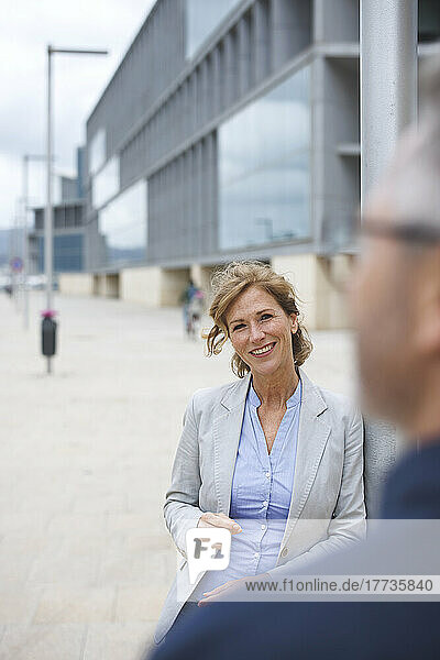 Smiling businesswoman standing in front of businessman
