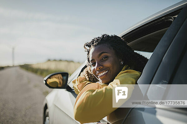 Smiling woman looking out through car's window