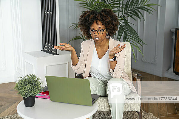 Frau gestikuliert bei Videoanruf über Laptop