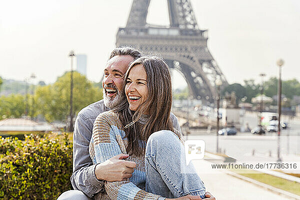 Fröhliches älteres Paar sitzt zusammen vor dem Eiffelturm  Paris  Frankreich