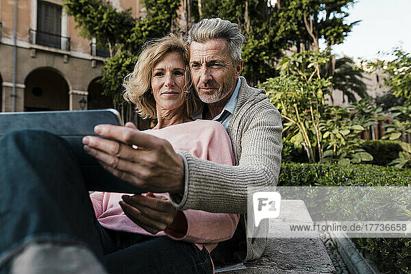 Älteres Paar benutzt Tablet-Computer im Park