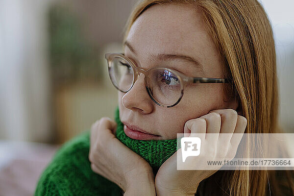 Thoughtful woman wearing eyeglasses at home
