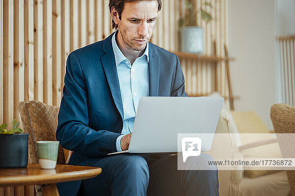Freelancer working on laptop sitting at cafe