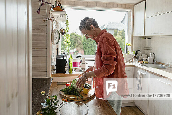 Woman with vegetables in kitchen at home