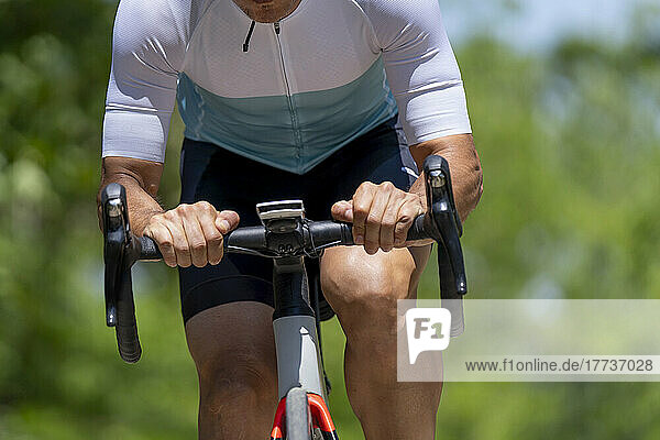 Sportler in Sportkleidung fährt an einem sonnigen Tag Fahrrad
