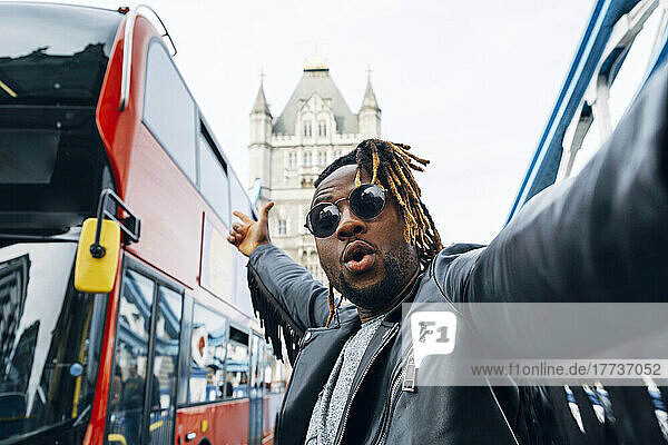 Carefree man standing amidst buses in city  London  England