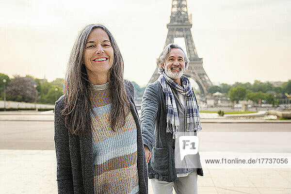 Happy mature woman with man in front of Eiffel Tower Paris France on sunny day