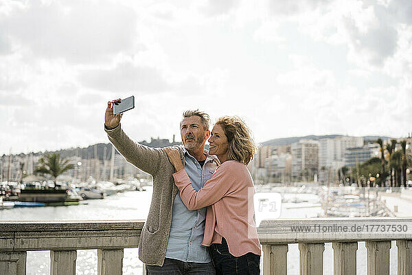 Reifer Mann macht im Urlaub ein Selfie mit Frau auf Smartphone