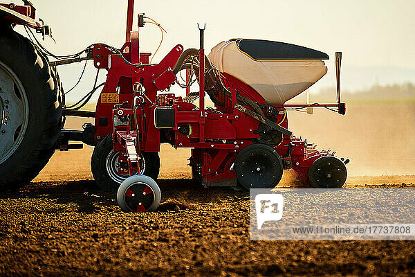 Tractor seeder sowing soybean seeds in field