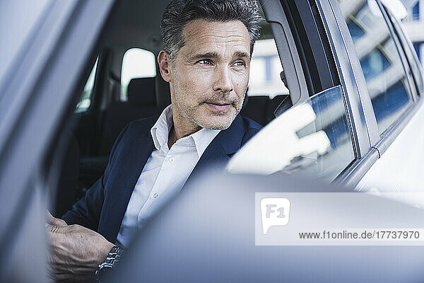 Mature businessman sitting in car