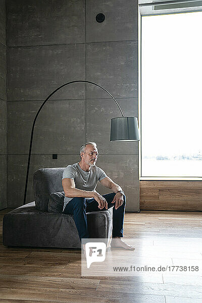Thoughtful man sitting on furniture at home