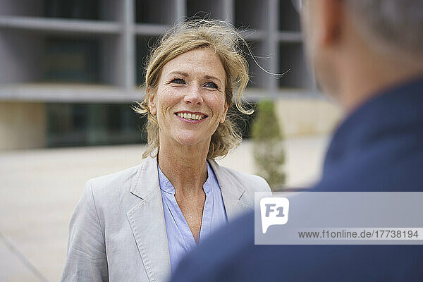 Smiling mature businesswoman discussing with colleague