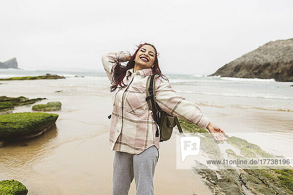 Happy woman with eyes closed enjoying at beach