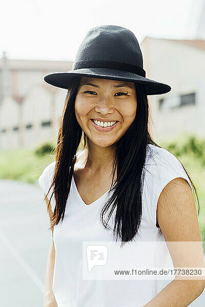 Happy beautiful woman wearing hat on sunny day