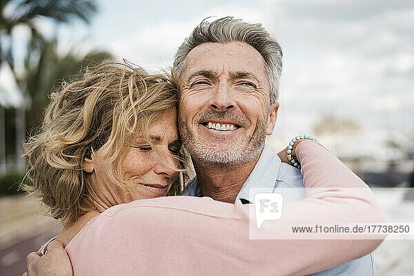 Happy mature couple embracing outdoors