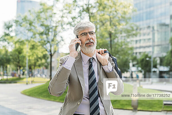 Businessman wearing eyeglasses talking on smart phone