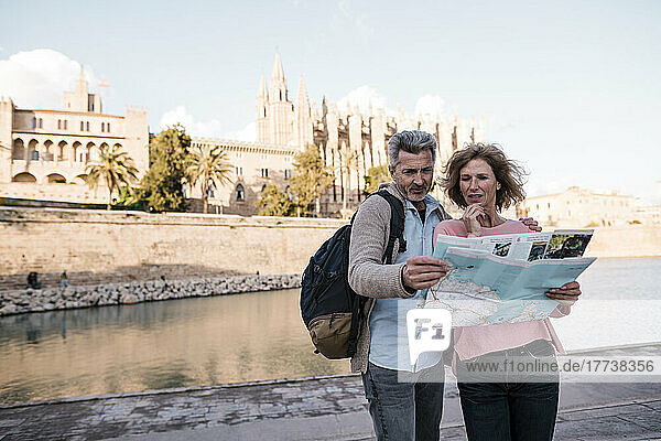 Mature couple reading map in city on vacation