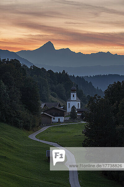 Germany  Bavaria  Wamberg  Road leading to remote village in Wetterstein mountains at dusk